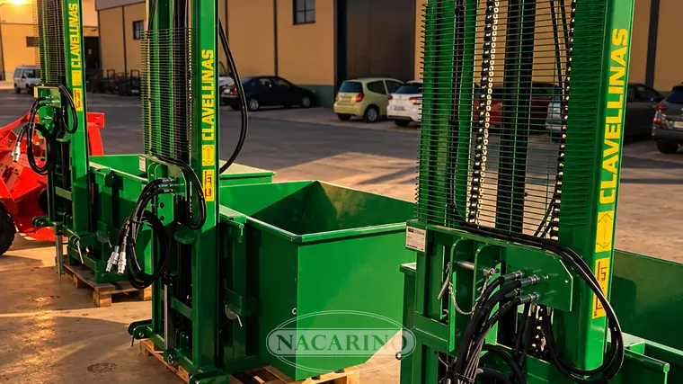 Elevador de mástil con cazo verde delante de la nave de Nacarino en Aceuchal