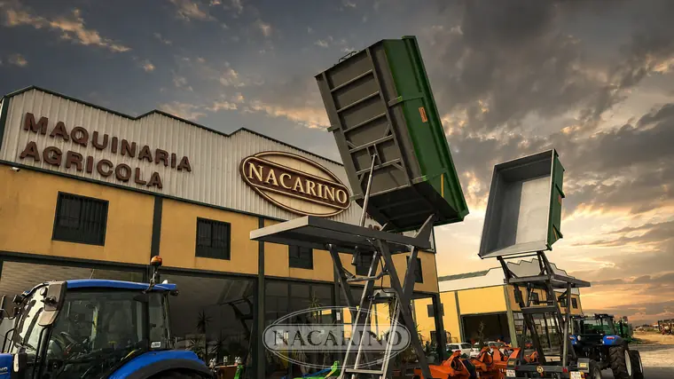 Remolque elevador de tijera verde con la caja subida sobre la plataforma hidráulica, delante de la nave de Nacarino en Aceuchal