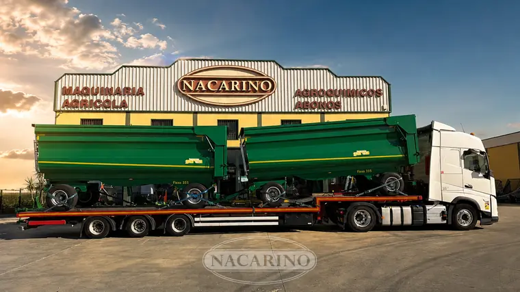 Camión con varias bañeras agrícolas nuevas cargadas para su entrega, delante de la nave de Nacarino en Aceuchal