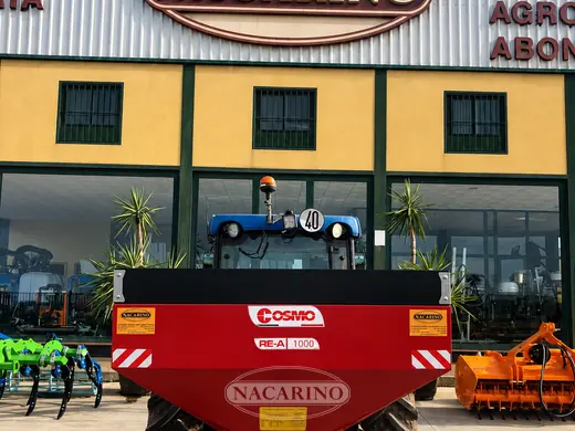 Abonadora Cosmo suspendida en tractor delante de la nave de Nacarino en Aceuchal