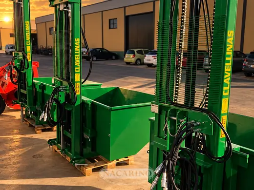 Elevador de mástil con cazo verde delante de la nave de Nacarino