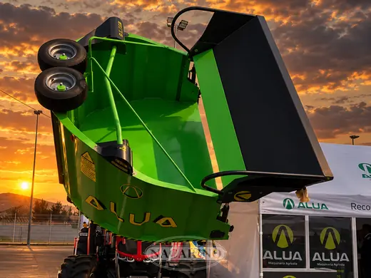 Tolva elevadora verde con mástil, en la campa de Nacarino al atardecer