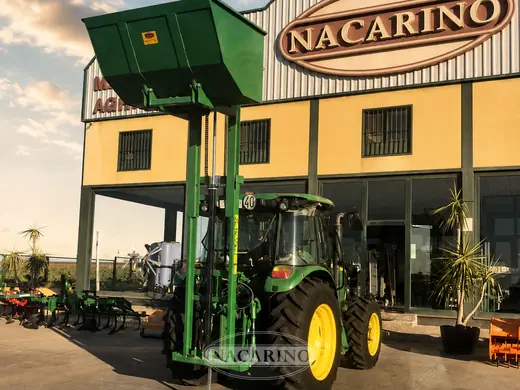 Tractor con tolva elevadora delante de la nave de Nacarino en Aceuchal