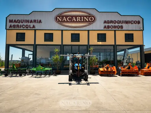 Tractor y aperos delante de la nave de Nacarino en Aceuchal