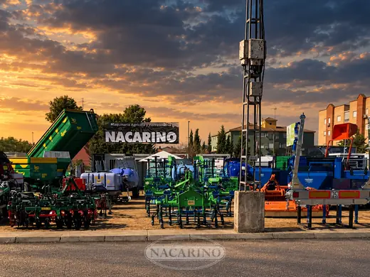 Stand de Nacarino en feria con maquinaria expuesta, al atardecer
