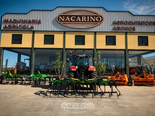 Chísel de brazos con rastra trasera, montado en tractor, delante de la nave de Nacarino en Aceuchal