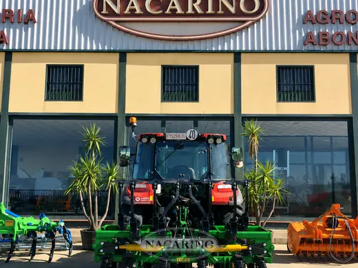 Tractor con cultivador de brazos delante de la nave de Nacarino en Aceuchal