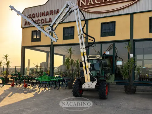 Barra de poda articulada sobre tractor delante de la nave de Nacarino en Aceuchal