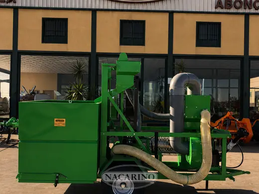 Equipo aspirador arrastrado, con tolva, turbina y mangueras de aspiración, vista lateral, delante de la nave de Nacarino en Aceuchal