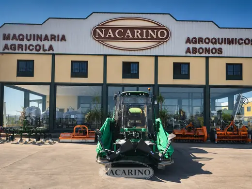 Paraguas vibrador para recolección de aceituna, plegado, montado en el frontal de un tractor delante de la nave de Nacarino en Aceuchal