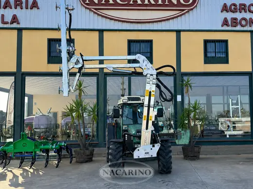 Tractor con barra de poda delante de la nave de Nacarino en Aceuchal
