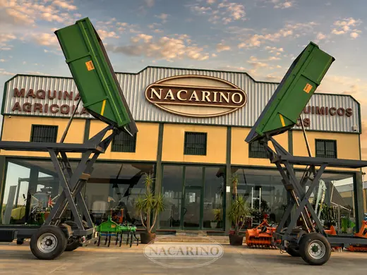 Remolques de tolva elevada, verdes, delante de la nave de Nacarino en Aceuchal